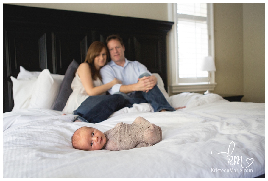 family on bed with newborn