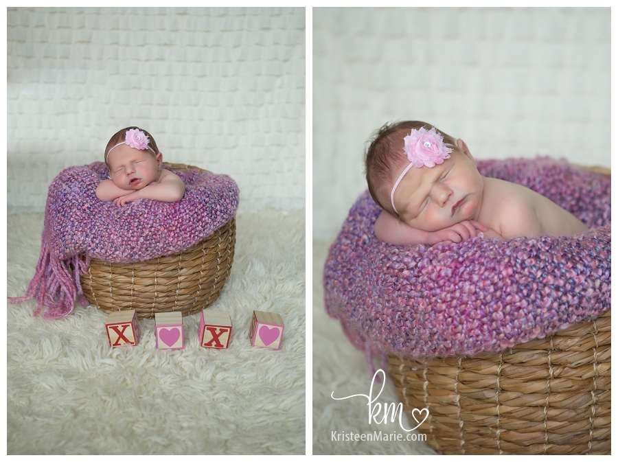newborn girl in basket and blocks