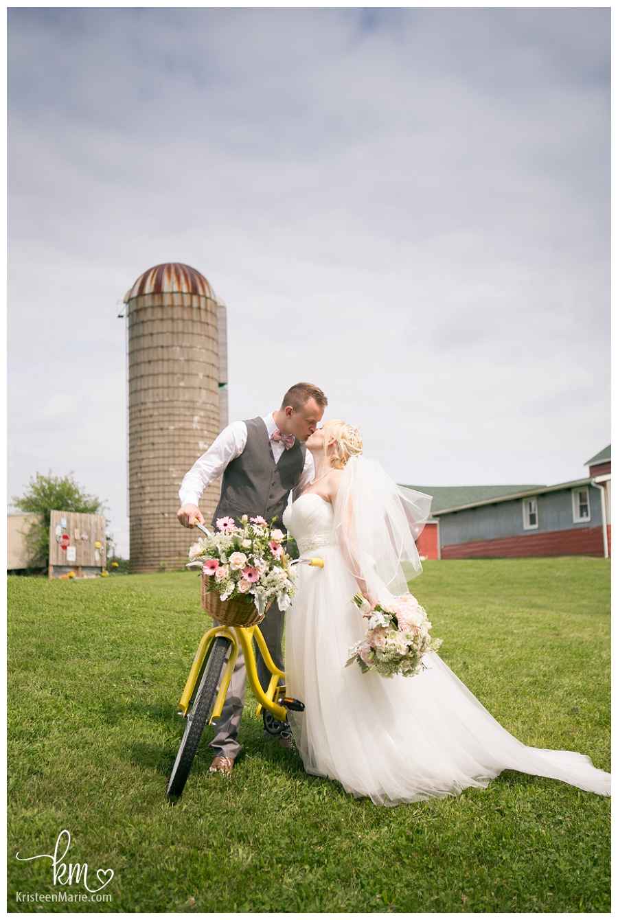 Wedding couple kissing in front of Avon Wedding Barn