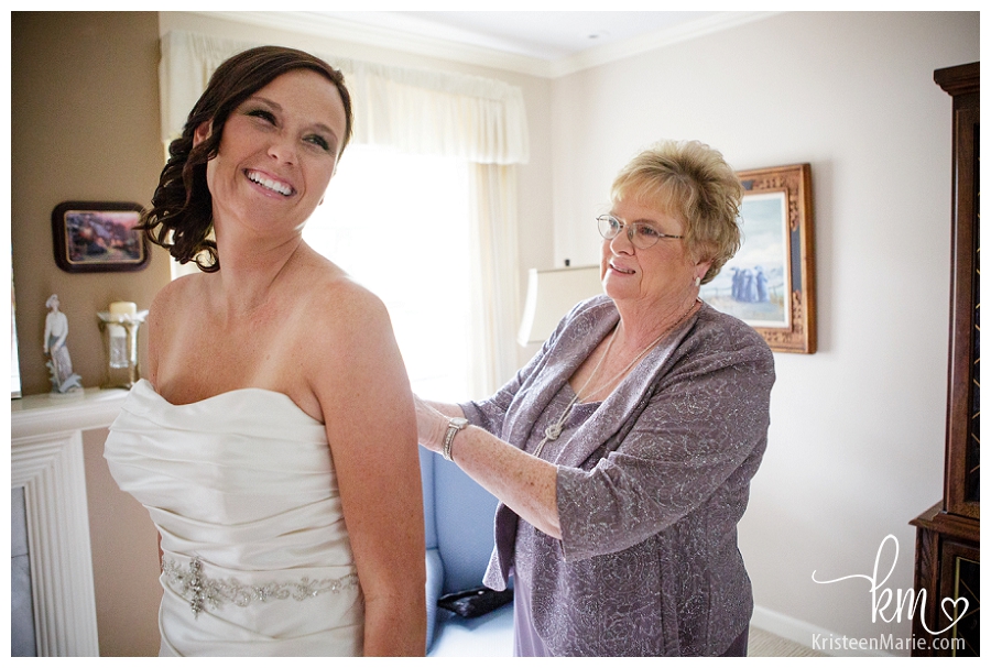 mom zipping her daughter into her wedding dress