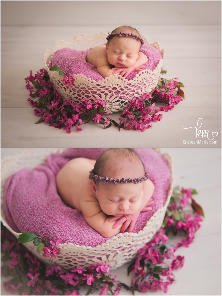 baby in a basket surrounded by flowers