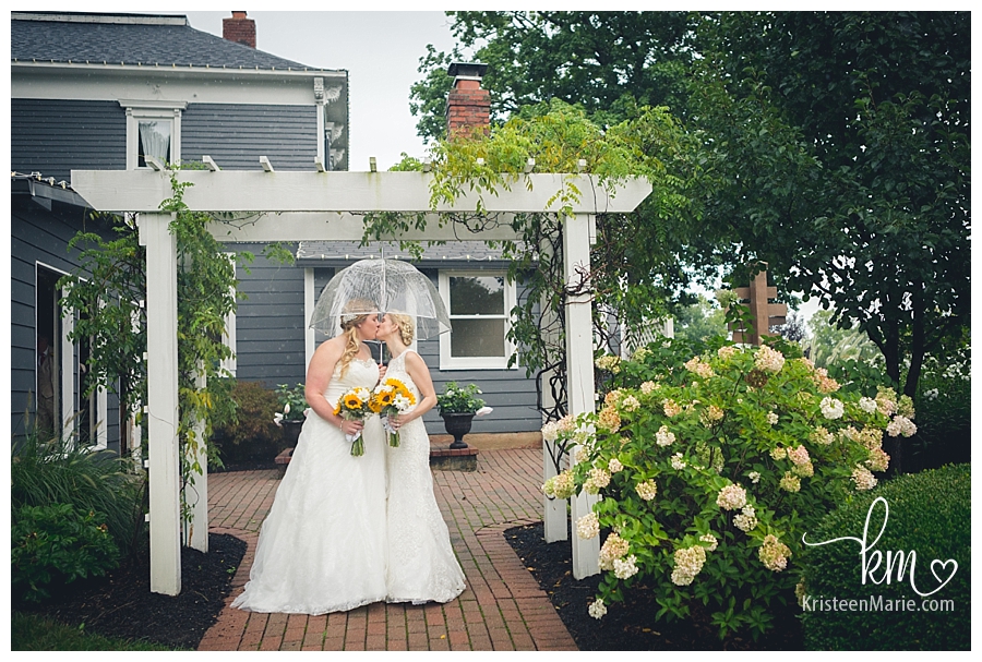 brides kissing at Mustard Seed Gardens