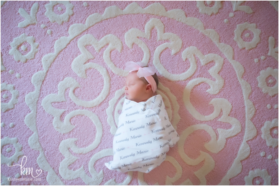sleeping newborn girl on pink rug