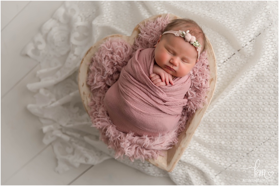 newborn baby girl in heart bowl