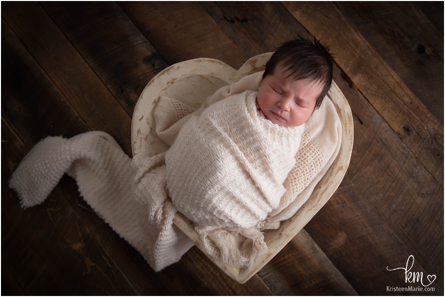 newborn baby girl in heart bowl
