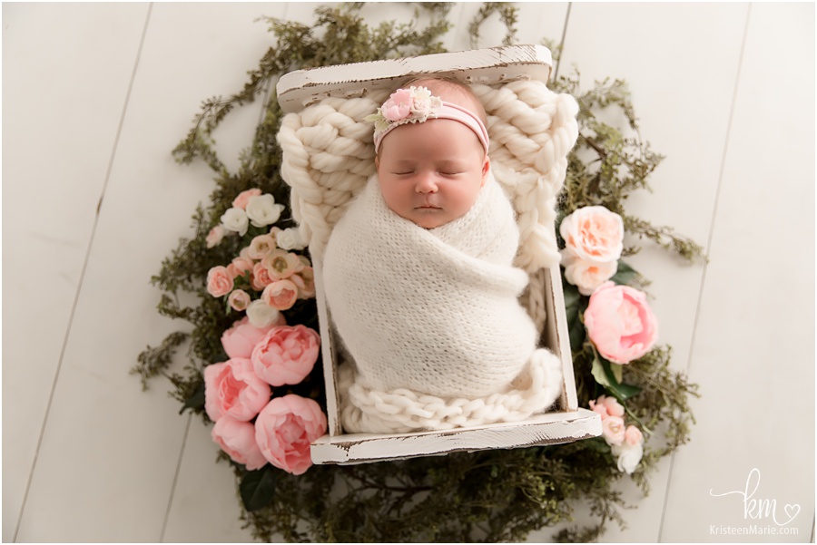 baby with flowers around her - blush and green newborn photo