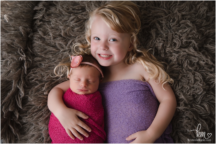 newborn baby girl with sister in photography studio in Indianapolis
