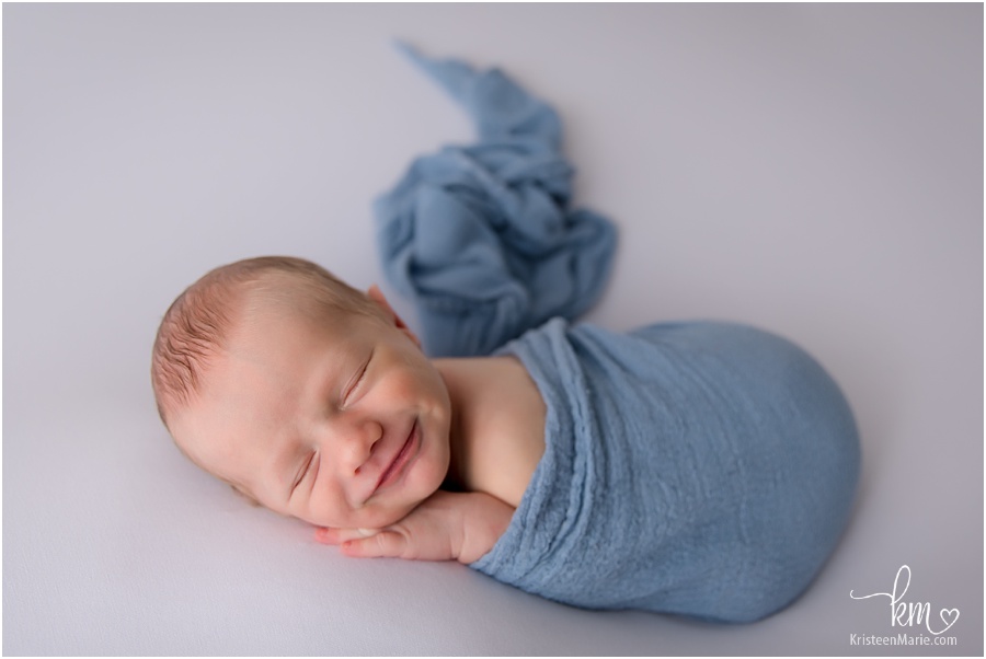 Smiling newborn boy in blue
