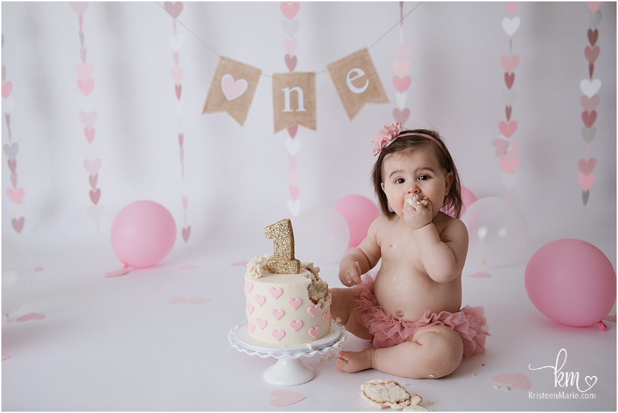 baby girl eating cake for 1st birthday