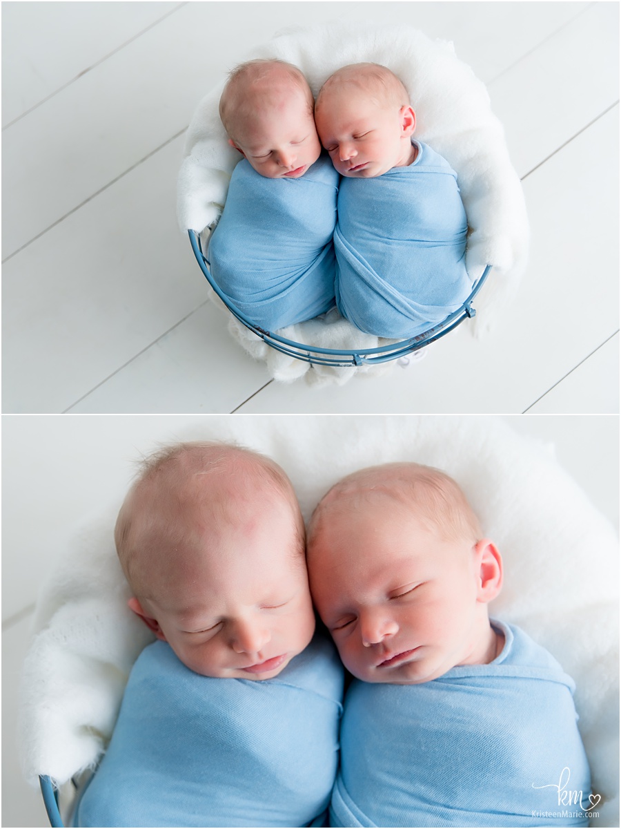 sleeping newborn boys in blue basket and wraps