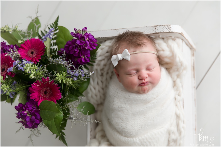 newborn girl with purple flowers