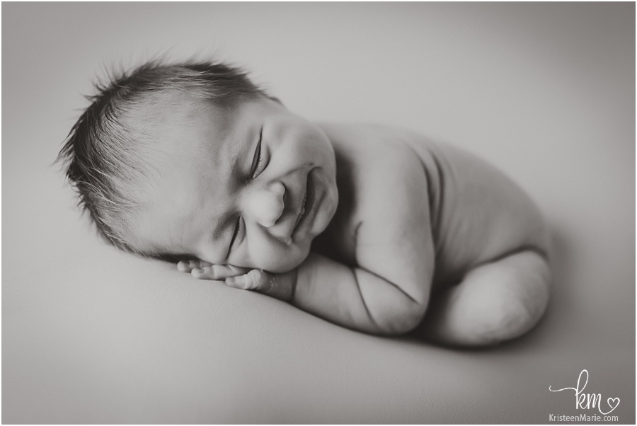 smiling newborn baby in black and white