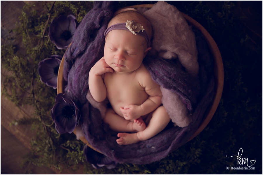 sleeping newborn girl in purple