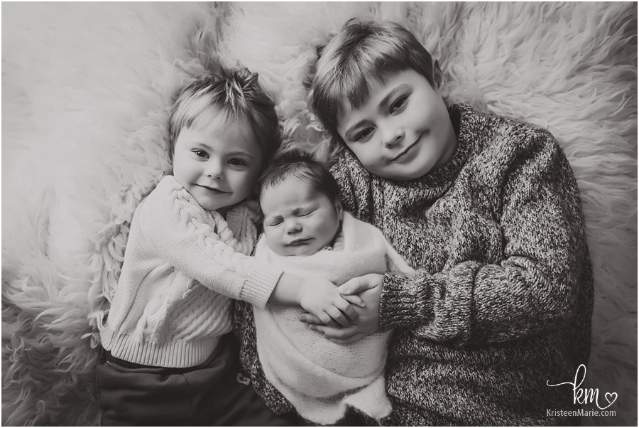 black and white image of three brothers - including newborn baby