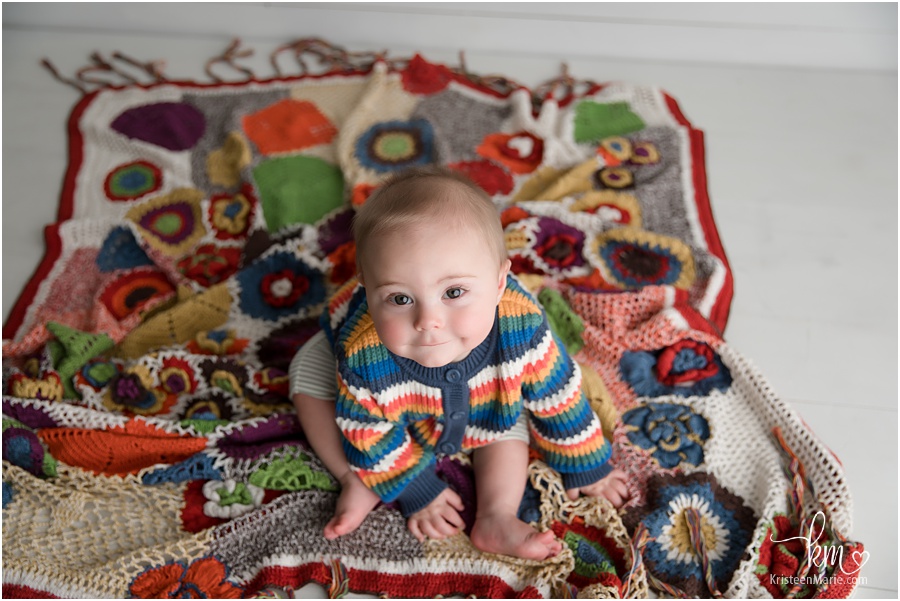 sitter baby on a quilt from home