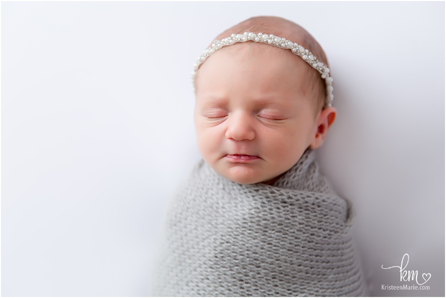 sleeping newborn girl with pearl headband