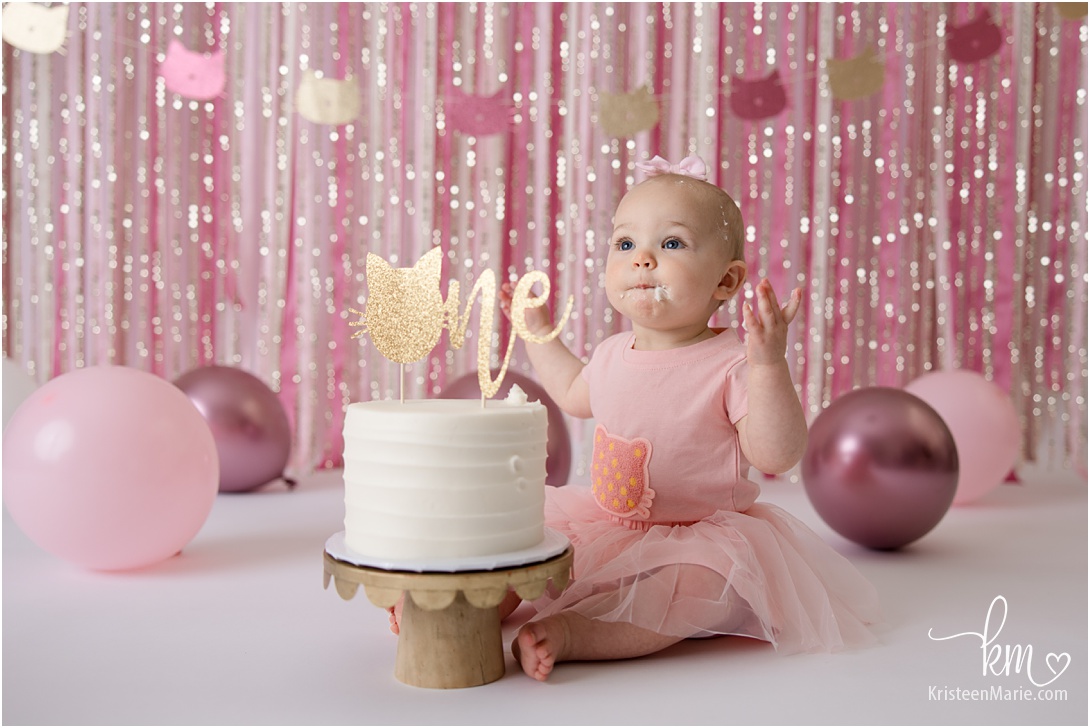 baby girl with first birthday cake