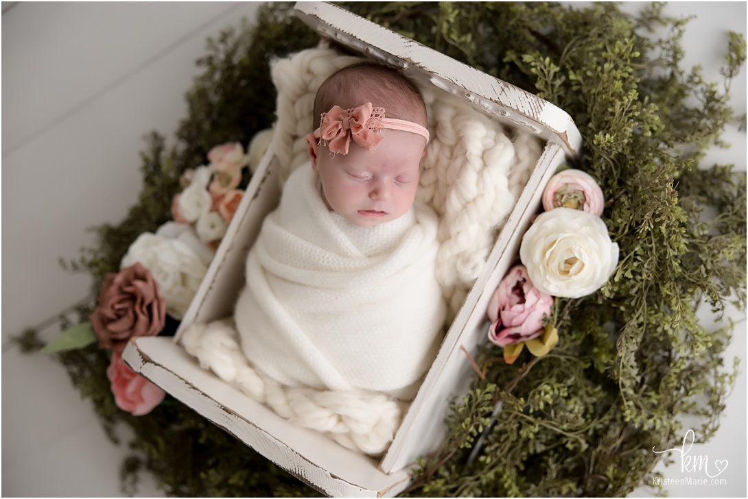 newborn photography of little girl with pink flowers