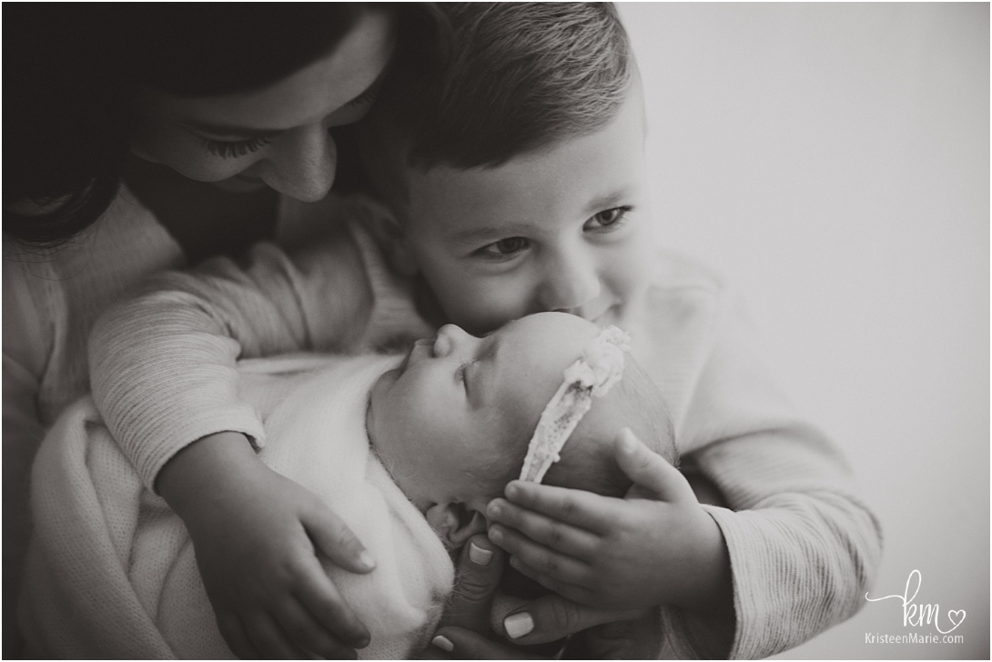 black and white sibling picture with newborn 