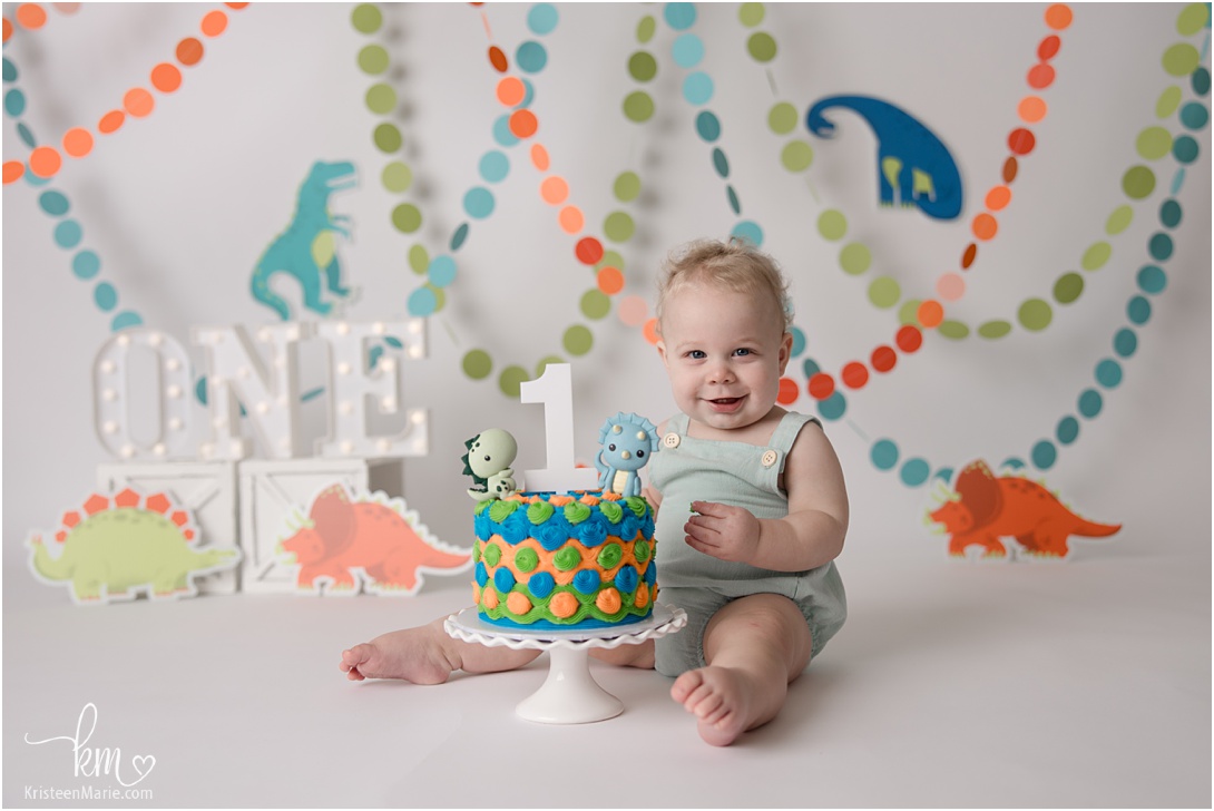 Dino themed first birthday cake smash session - green, teal, blue and orange
