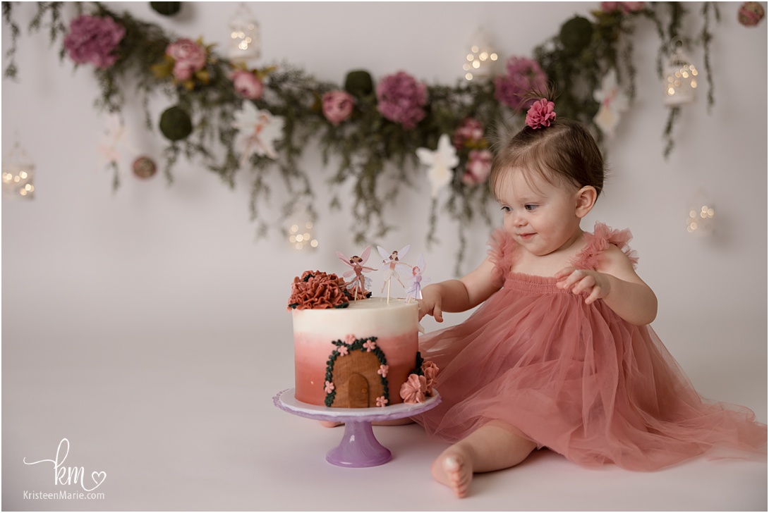 birthday girl smiling at smash cake