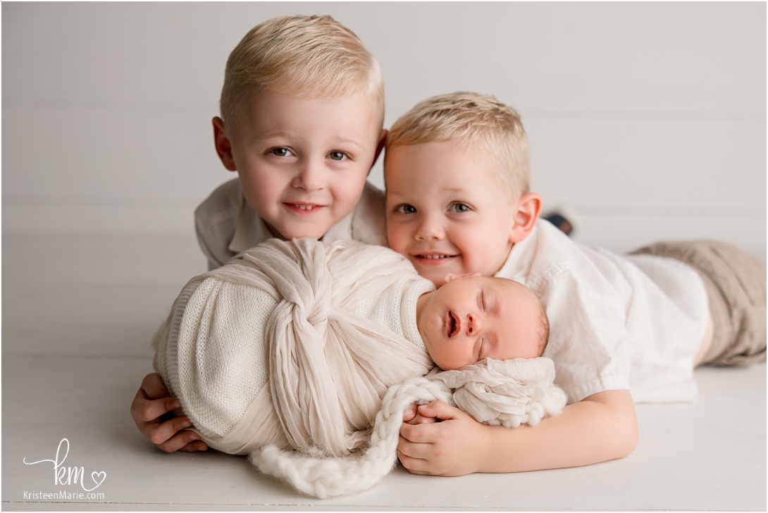 two big brothers with newborn baby brother