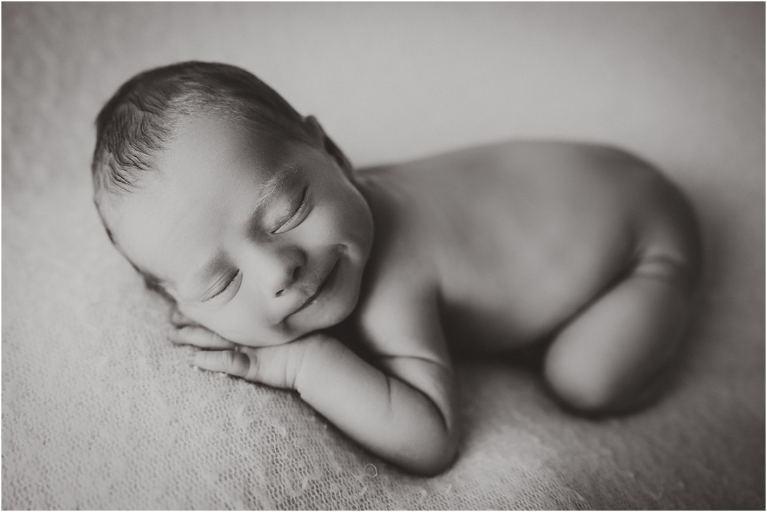 smiling newborn baby boy in black and white