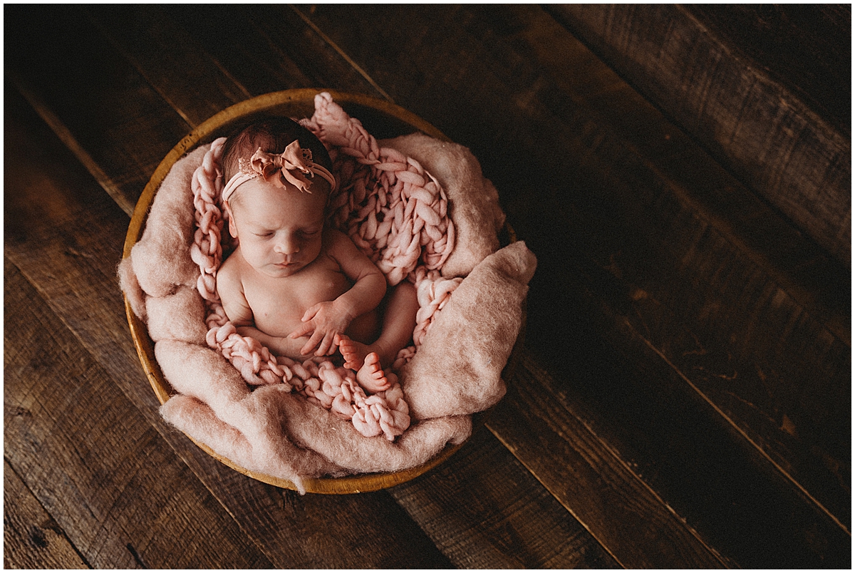 sleeping newborn girl in round bowl and pink fluff - so cute