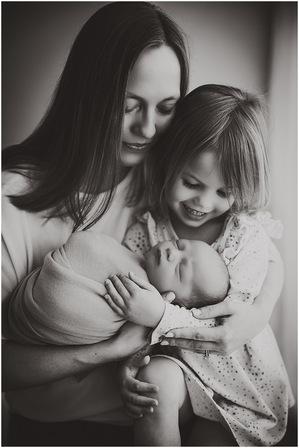 Newborn photography in black and white with mother and two kids
