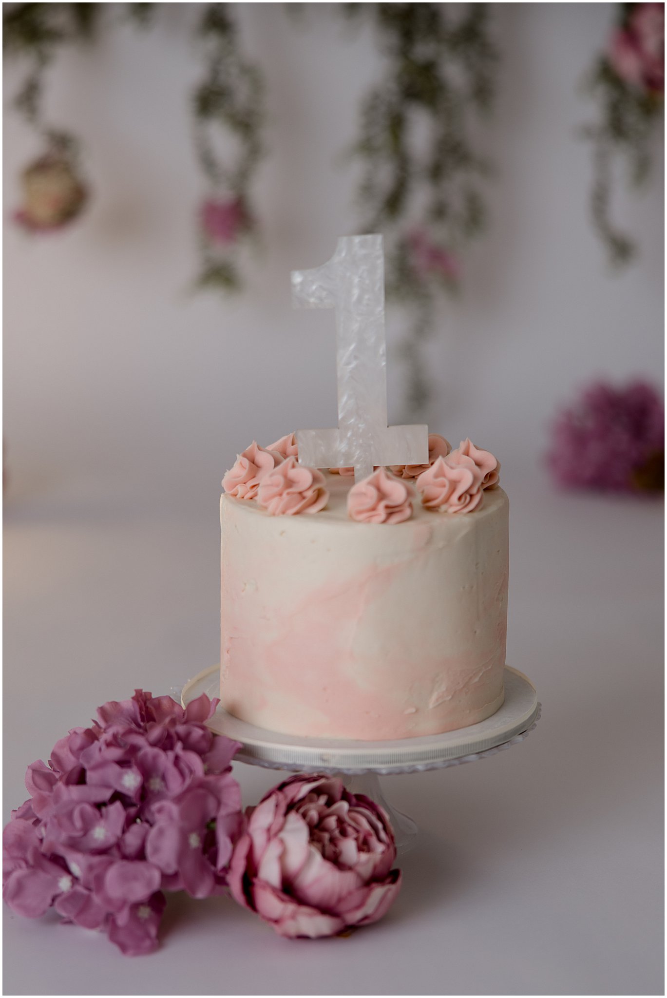 First birthday cake with pink rosettes and acrylic number one topper in Zionsville studio