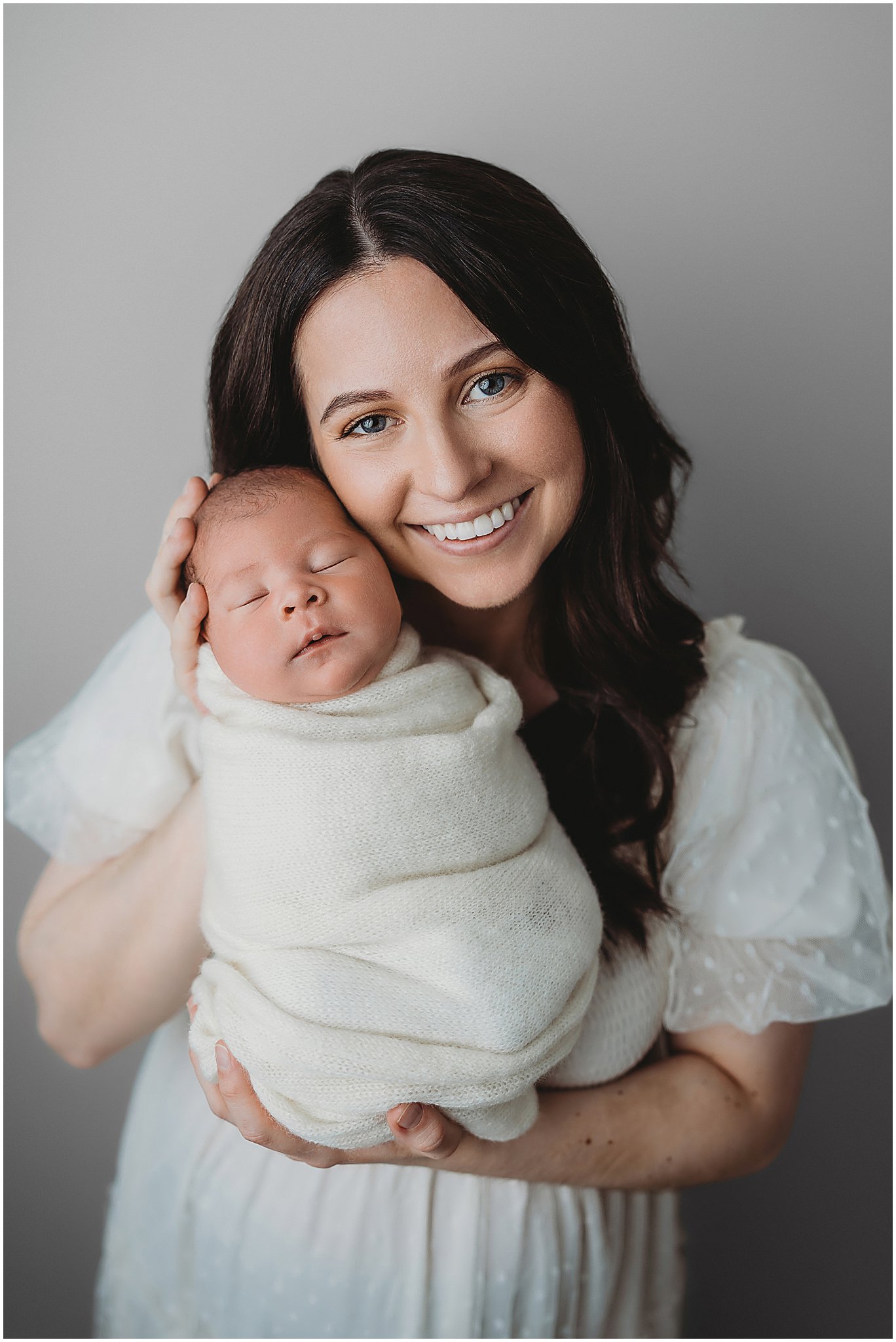 Mom holding her baby with love during a relaxed Indianapolis newborn photography studio session.