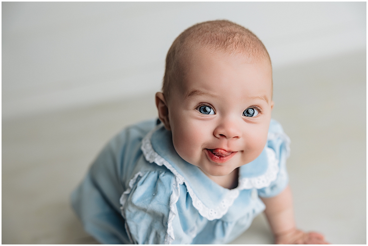 Six-month-old baby smiling at camera during milestone photo shoot in Indianapolis studio
