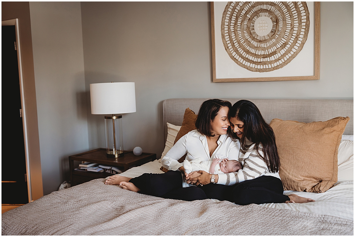Zionsville newborn photographer capturing first-time same-sex parents holding their baby at home