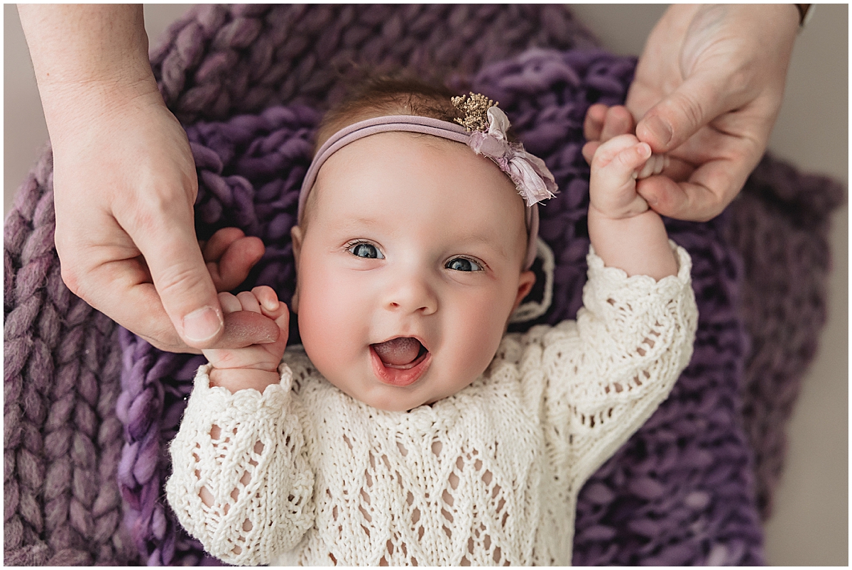 Smiling 3 month old baby on purple blanket during Indianapolis newborn photography