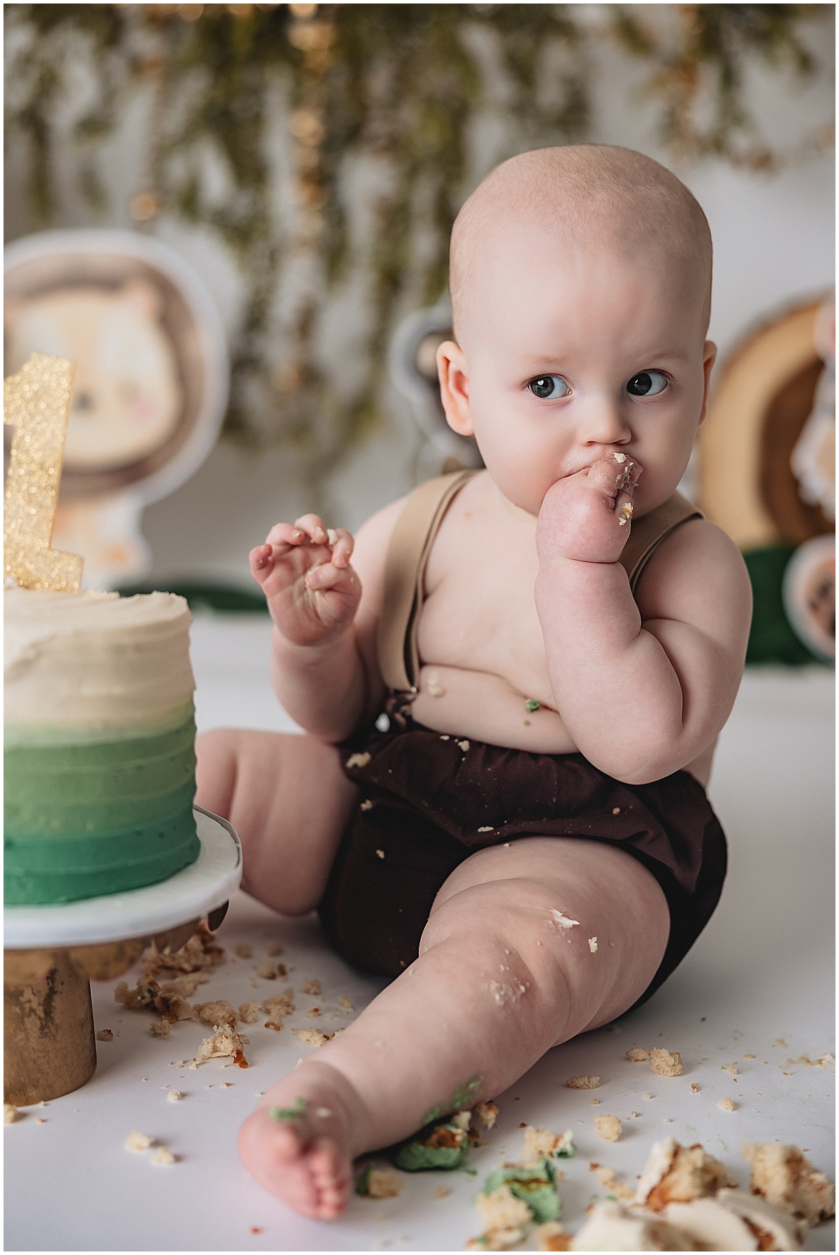 One year old boy eating cake with suspenders outfit - Indianapolis photographer