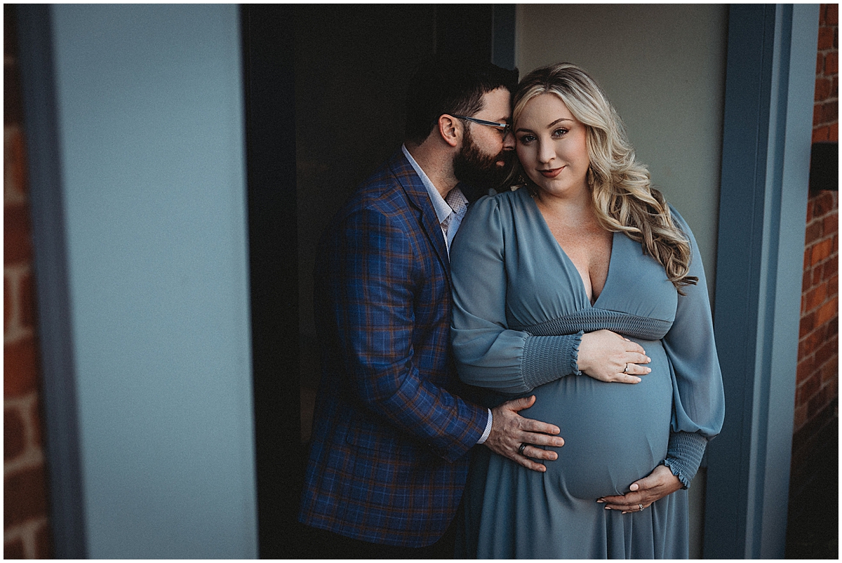 Expecting parents sharing quiet moment in doorway during downtown Zionsville maternity session