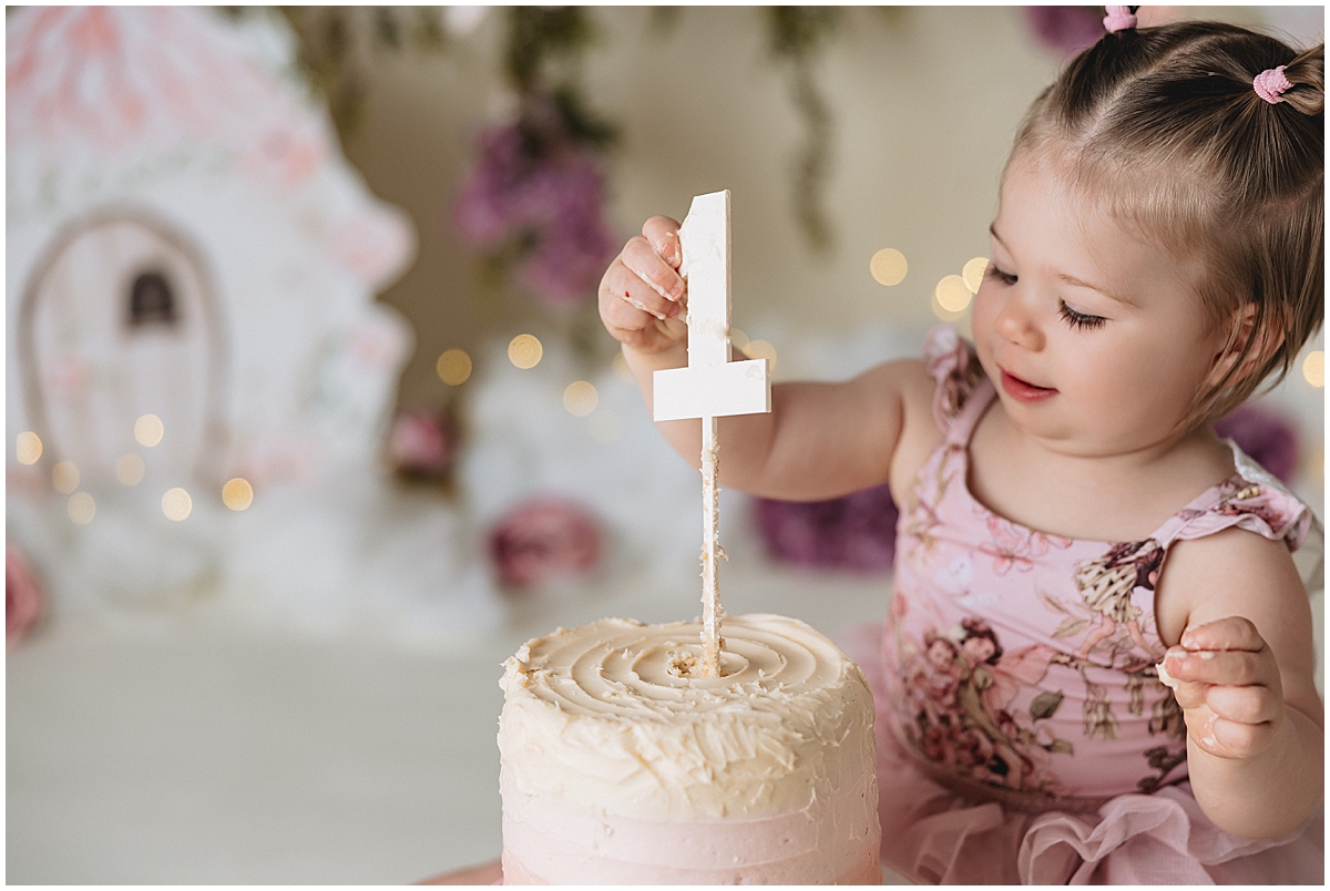 Indianapolis photographer captures baby girl exploring first birthday cake topper