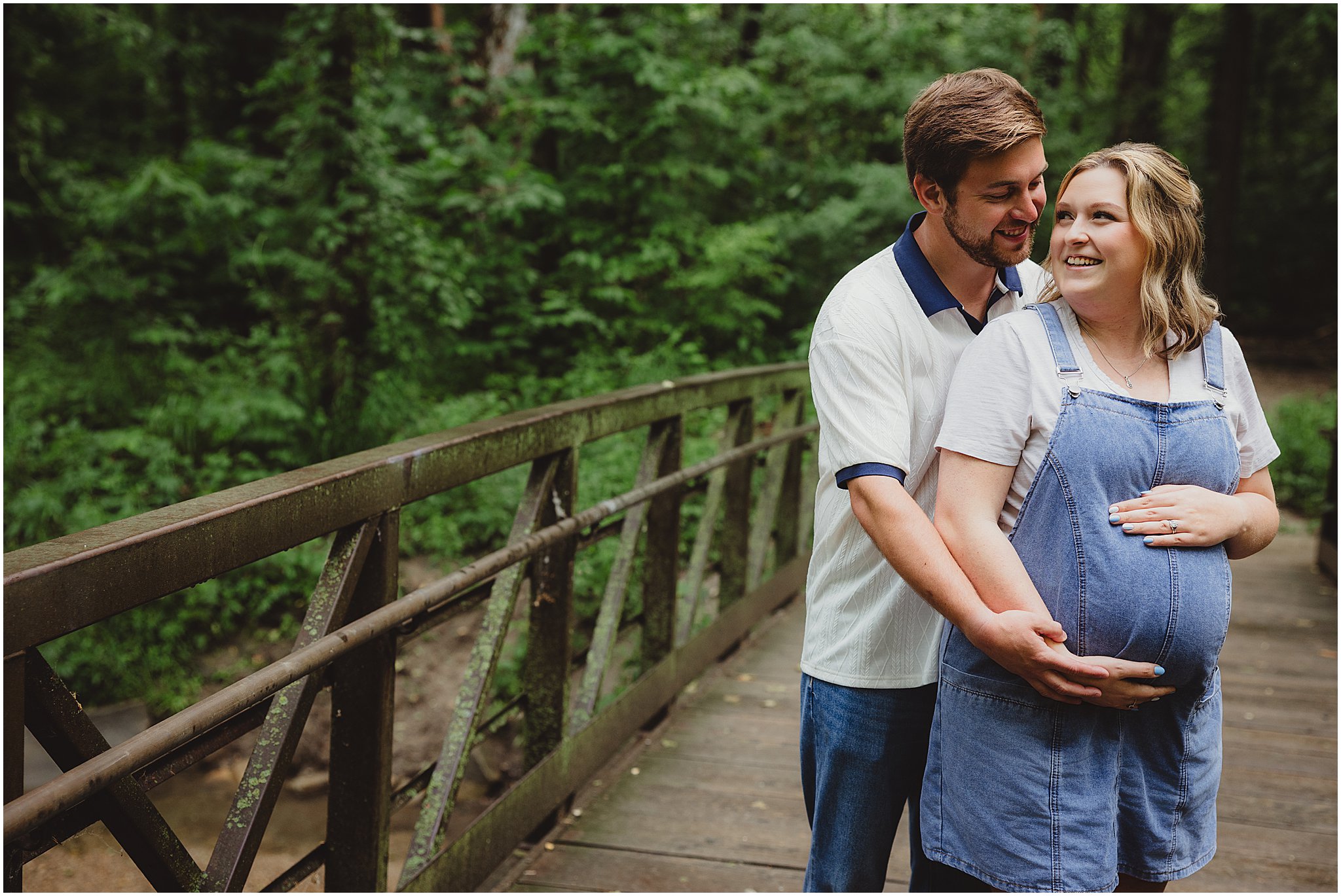 Expecting parents cuddling on a bridge during an outdoor maternity session in Indianapolis.