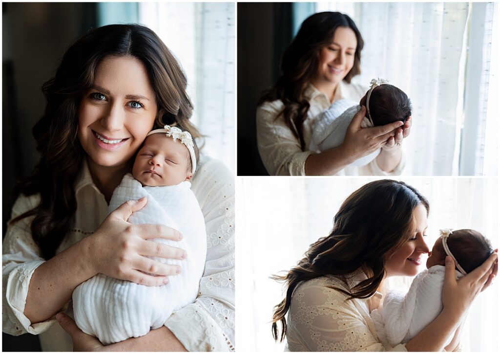 Mother holding and cuddling her newborn baby beside a softly lit window.
